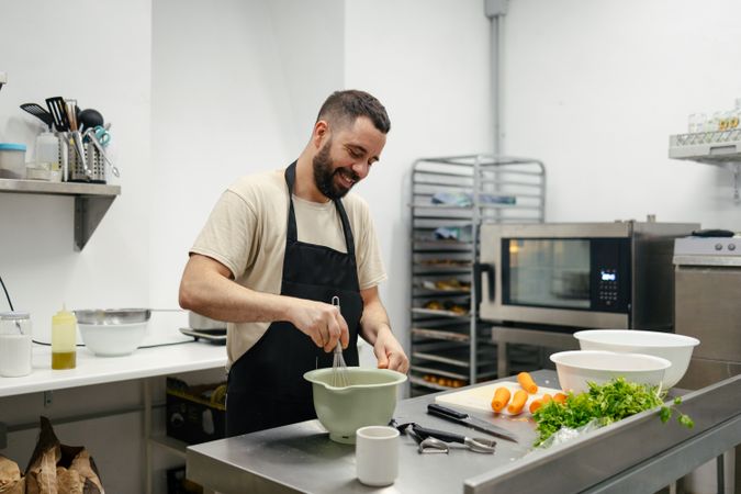 Young chef stirring with cooking rod
