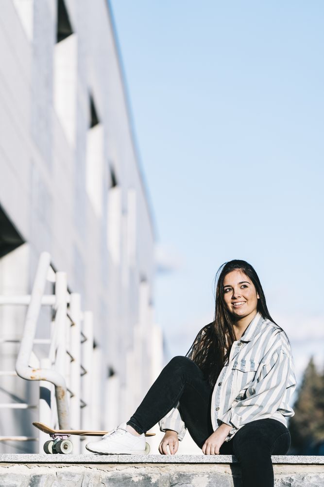 Young woman posing with skateboard