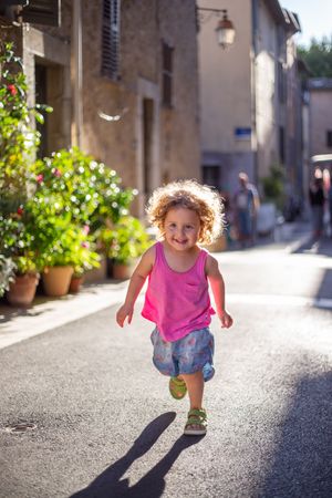 Smiling child running on street