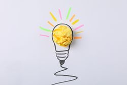Drawn light bulb and paper ball on light background. Good idea concept