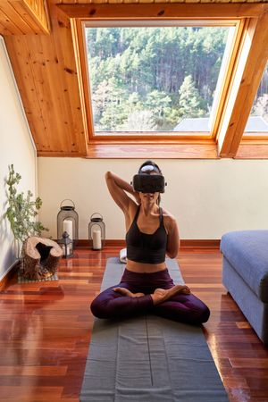 Woman sitting with crossed legs and exploring VR goggles