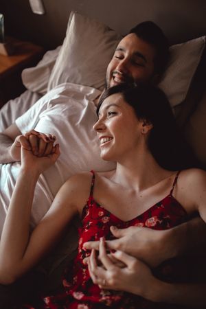Happy couple cuddling on bed
