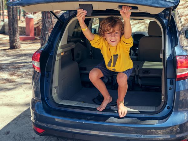 Smiling preteen boy playing in car