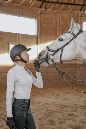 Rider with dapple gray horse in round arena