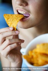 Close up of girl snacking on nacho chips 4NEmd2