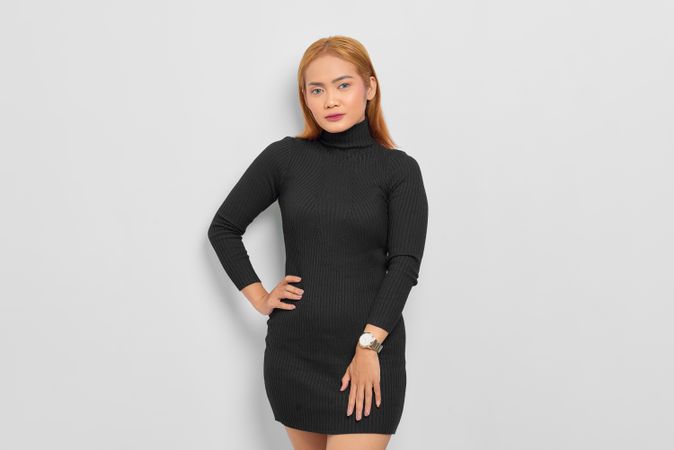Asian woman with red hair in dark dress in studio shoot