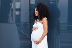 Smiling pregnant woman in long dress