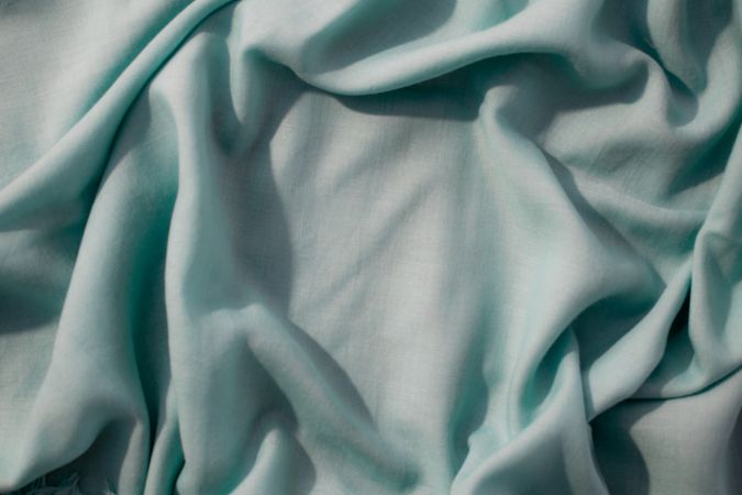 Nude green fabric wavy crumpled background texture with copy space.