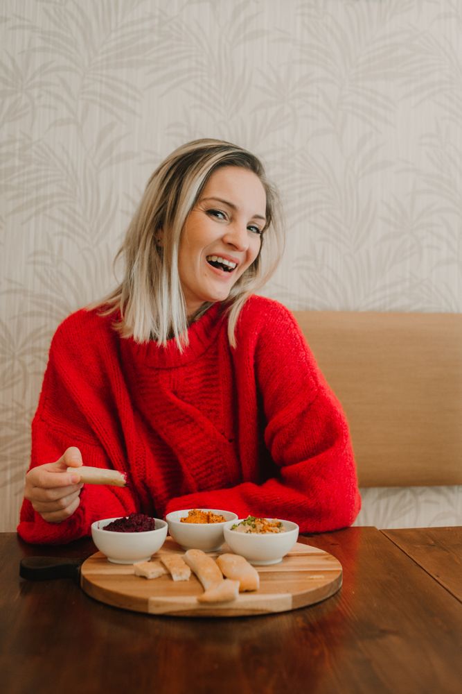 Woman smiling eating assorted food at table