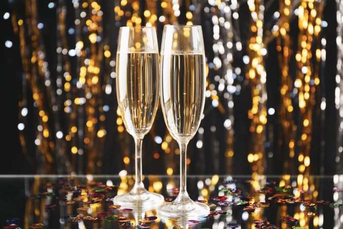 Champagne glasses on blurred background, space for text