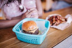 Cheeseburger in a  basket on a wooden table