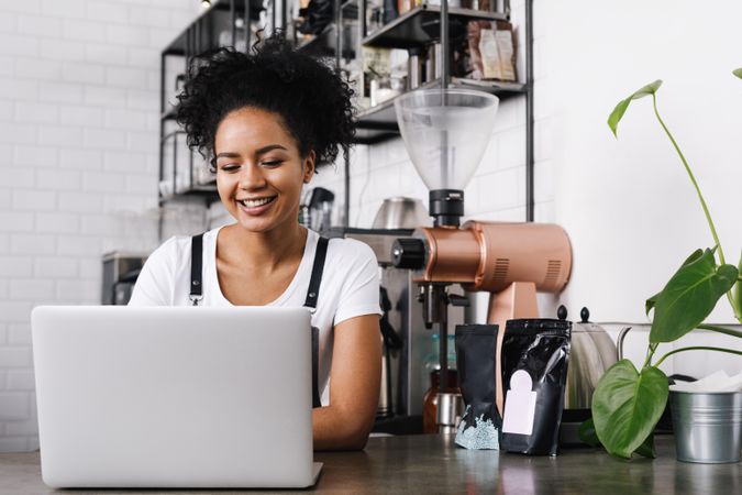 Smiling coffeeshop owner at laptop