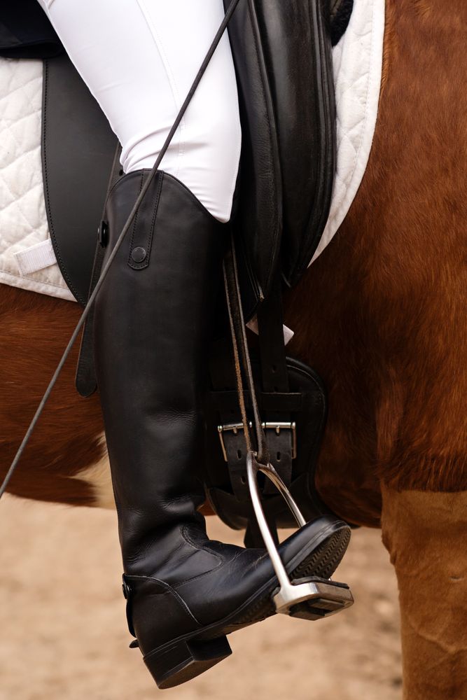 Rider's foot secured in stirrup, detailed view.