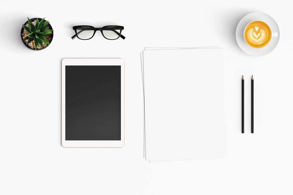 Modern workspace with coffee cup, smartphone, paper, notebook, tablet copy space