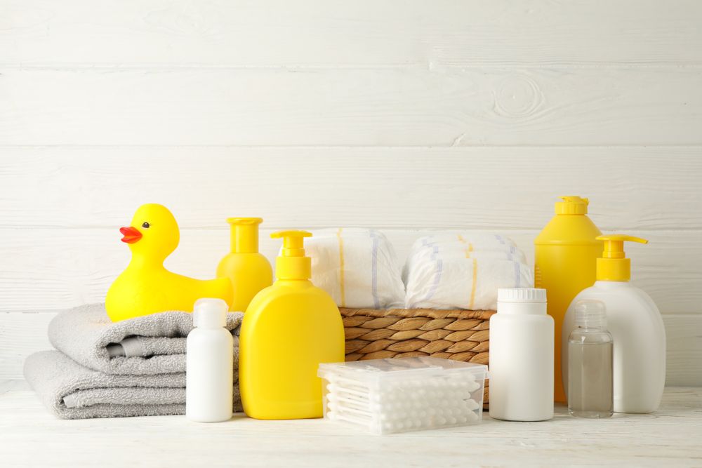 Baby hygiene accessories on light wooden background