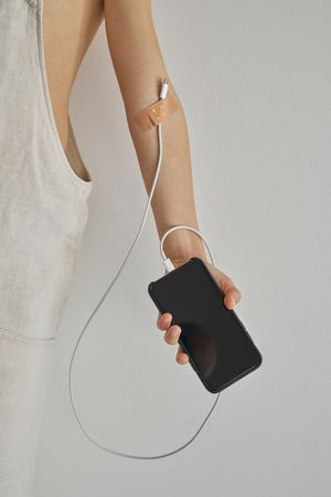 Crop child with charging cable attached to arm