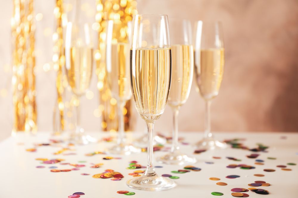 Champagne glasses on decorated background, space for text