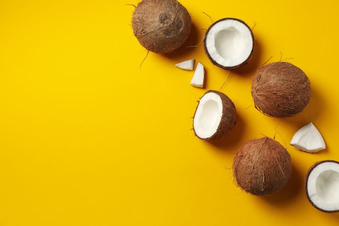 Flat lay with coconut on yellow background, space for text