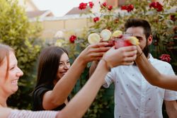 Group of cheerful friends clinking glasses at party