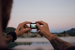 Screen of man’s camera looking out at lake