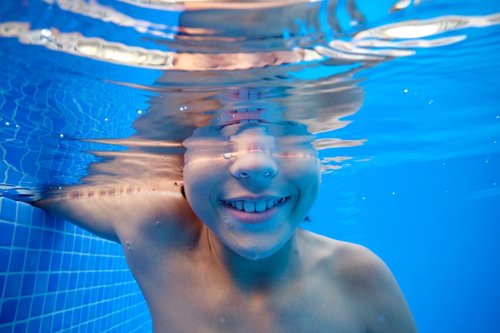 Positive boy in clean swimming pool