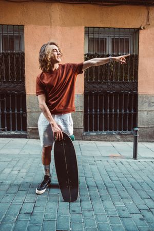Man carrying longboard on the street