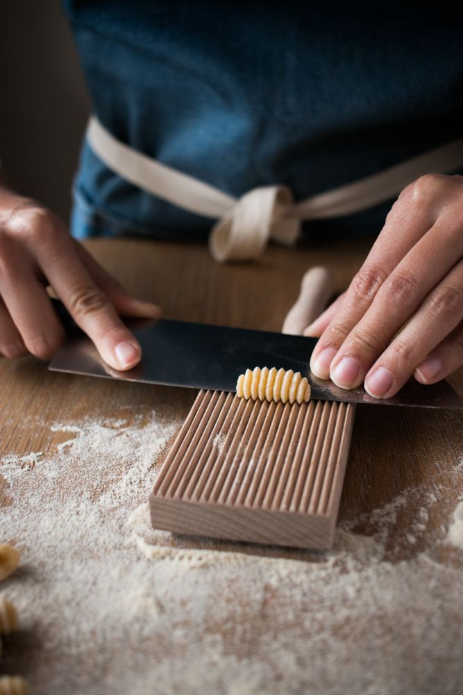 Crop woman making gnocchetti pasta