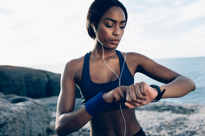 Fit female runner using smart watch to monitor her performance