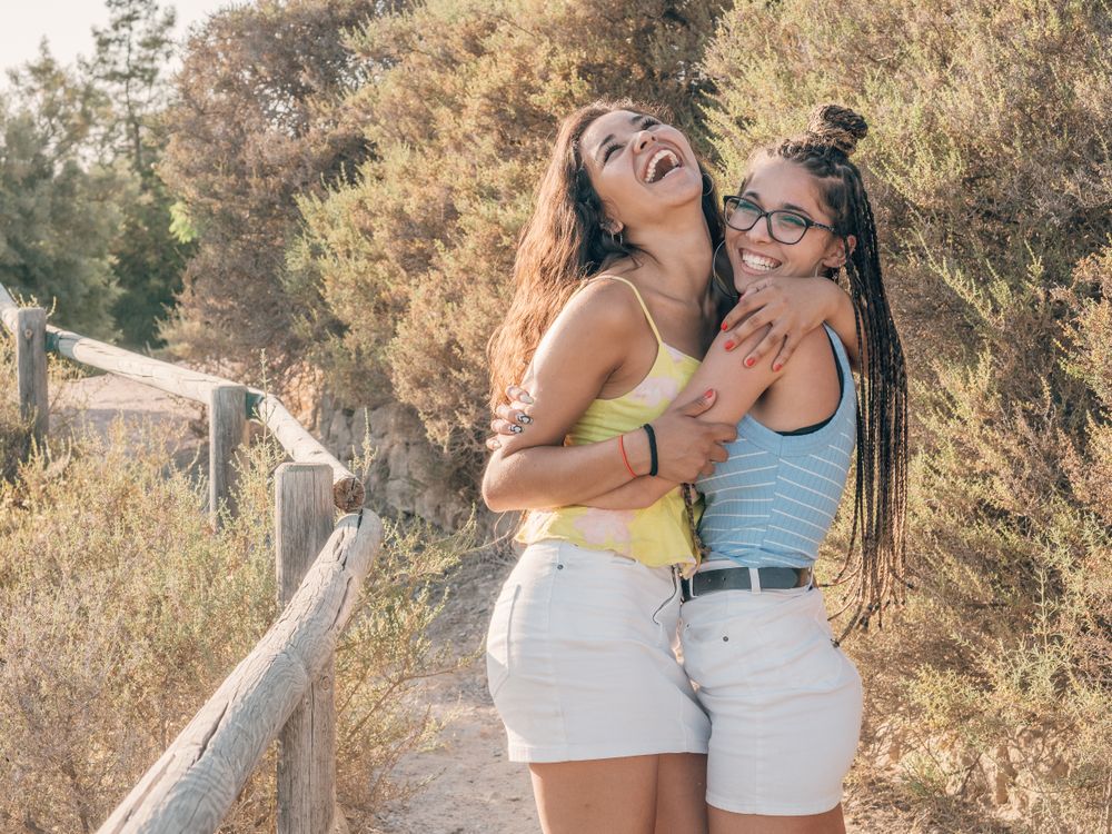 Happy trendy young women bonding at countryside