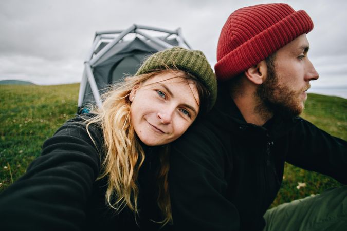 Woman leaning on man in front of tent