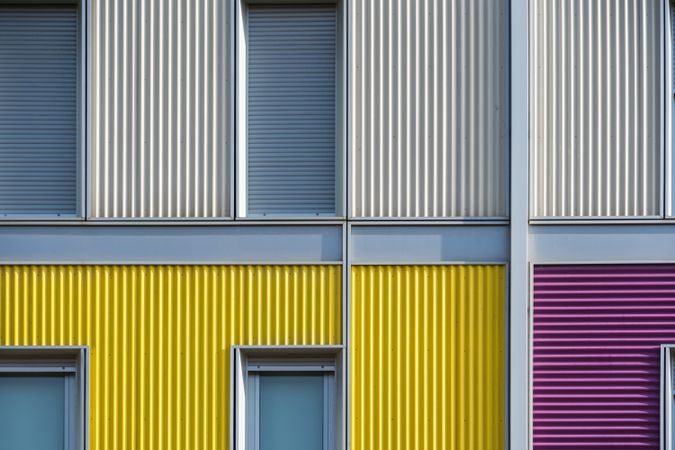 Facade of modern multicolored building with narrow windows