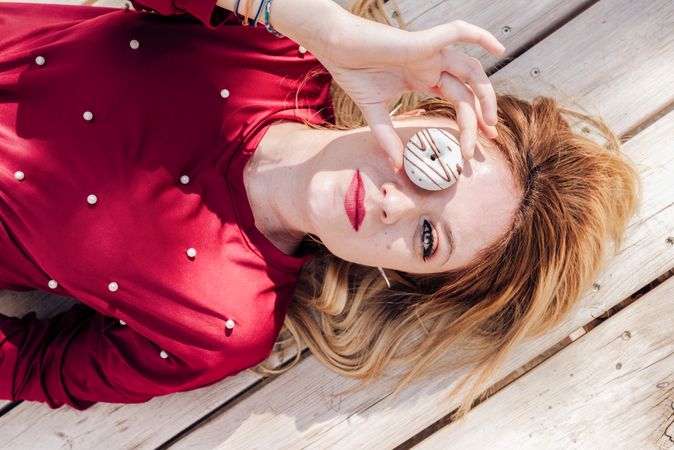 Woman looking through donuts hole on picnic