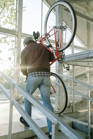 Back view of a man holding a bicycle