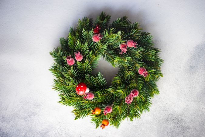 Top view of Christmas wreath with red berries on marble counter