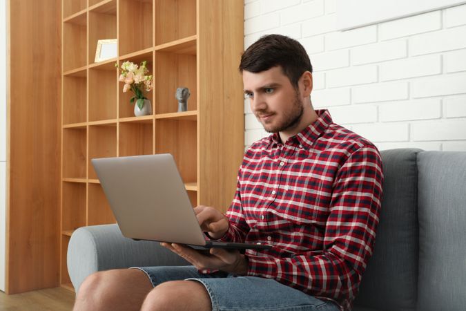 Young man working on laptop in modern flat