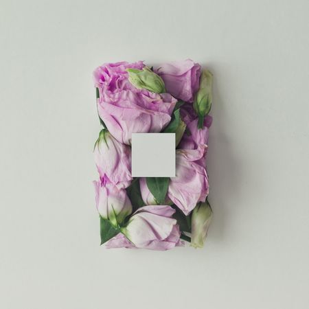 Pink flowers in shape of a gift box with light paper card on background