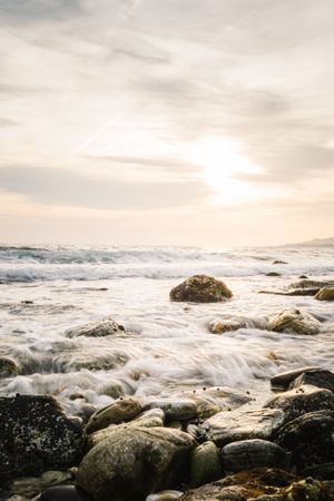 Stony seashore and waves at beautiful sunset