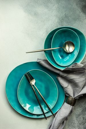 Top view of teal table setting on grey counter