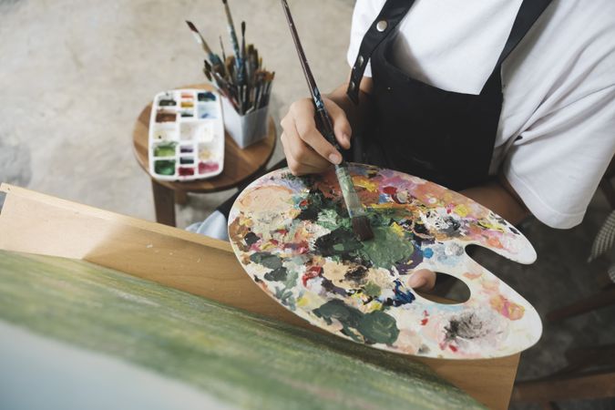 Crafting Inspiration: Female Artist Sketching and Painting in Workshop