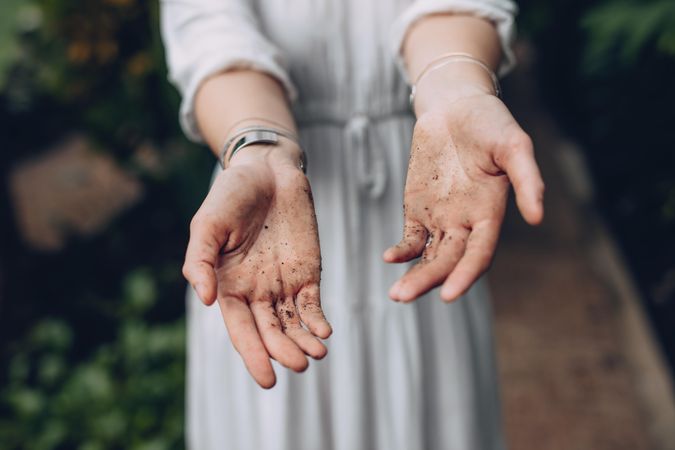 Cropped shot of female gardener hands showing her hands covered in dirt