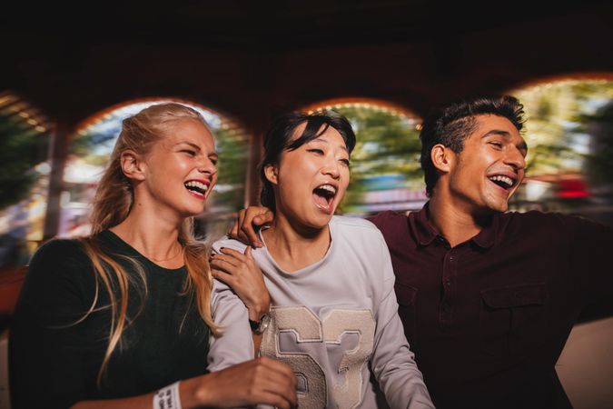 Group of friends on amusement park ride laughing