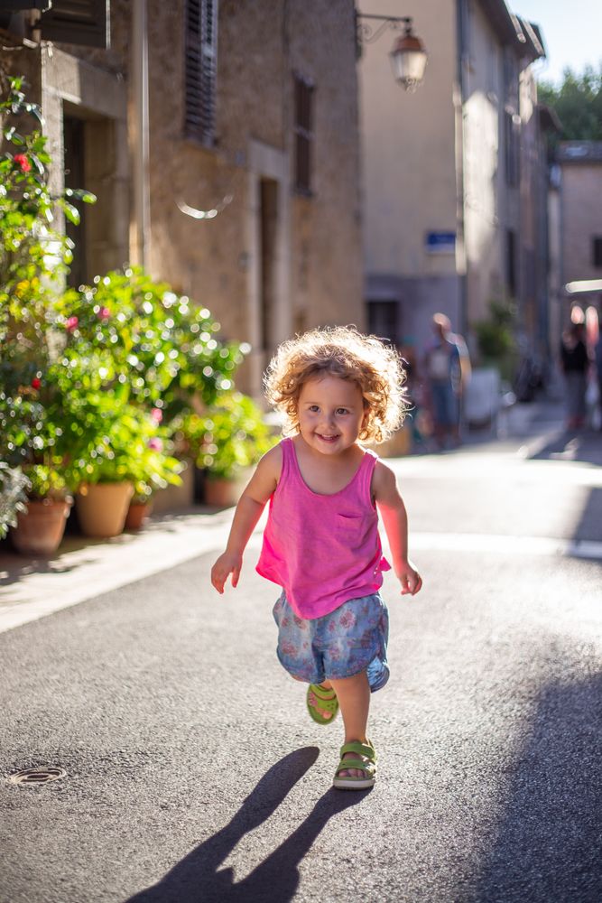 Smiling child running on street