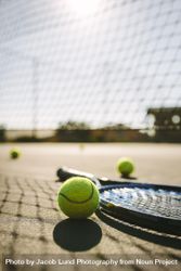 Ground level shot of a tennis racket with balls on tennis court 5lNZ7b