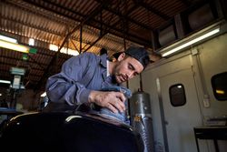 Bearded mechanic repairing motorcycle in garage