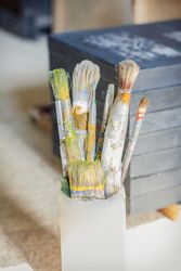 Set of paint brushes in front of canvas
