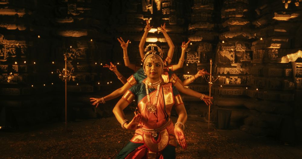 Enchanting Dynamic Shot Showcasing a Lively Ensemble of Indian Women Joyfully Dancing Traditional Folk Inside an Empty Historic Temple.
