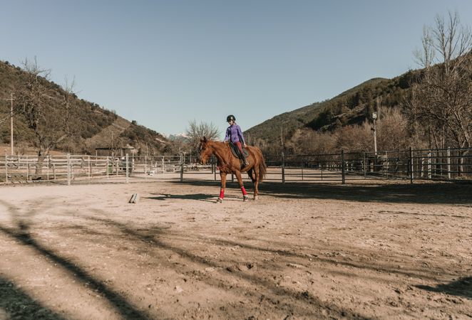 Young woman riding horse on ranch