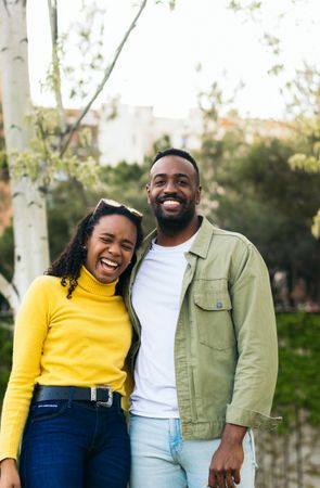 portrait of a Black couple laughing in a park