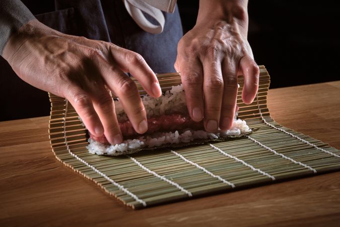 Male shushi man hands preparing different pieces of makis