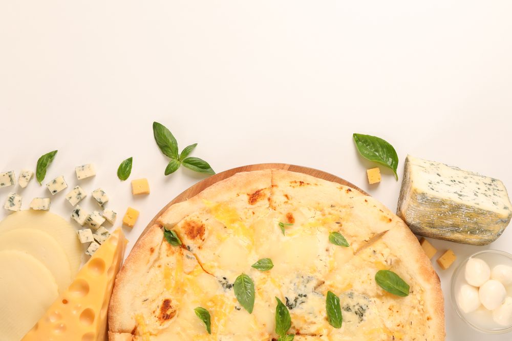 Flat lay. Cheese pizza and ingredients on plain background, copy space